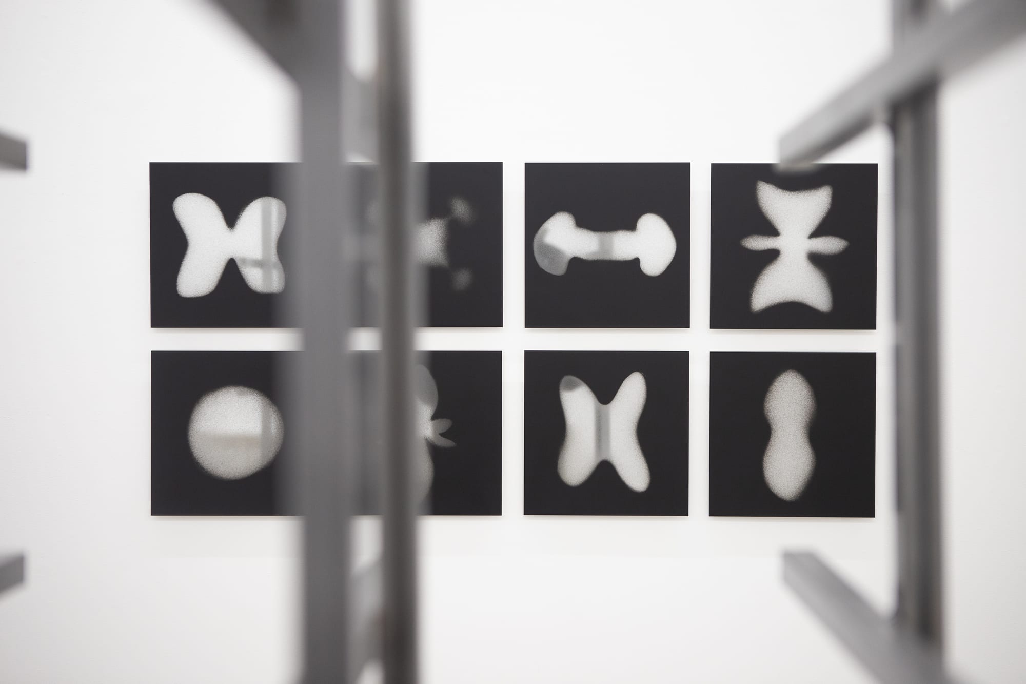 Blurred steel grid sculpture in front of the atom-shape photograph grid