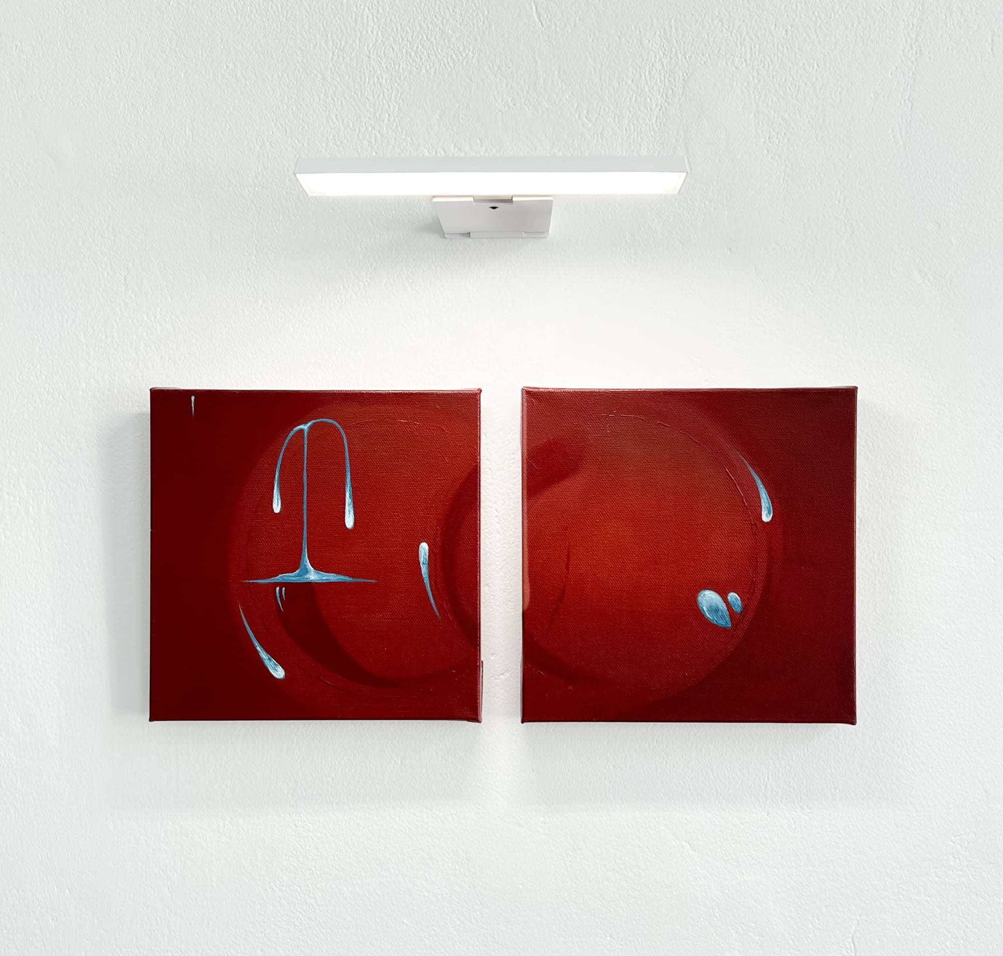 Red two-panel painting beneath a gallery light